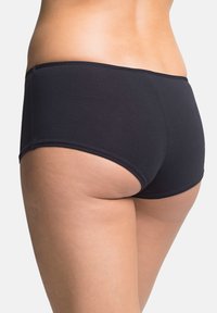 Boyshorts in cotone nero con una texture morbida, design a vita bassa e bordi senza cuciture per il massimo comfort. L'elastico si posiziona leggermente sopra i fianchi.