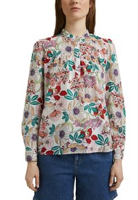 Blouse à manches longues en tissu léger. Présente des motifs floraux multicolores avec des feuilles vertes, un col à boutons et des détails plissés.