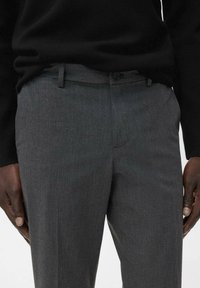 Grijze comfortabele broeken van een gladde stof, met een rechte voorkant, knoopsluiting en riemlussen. Eenvoudig, modern ontwerp zonder patronen.