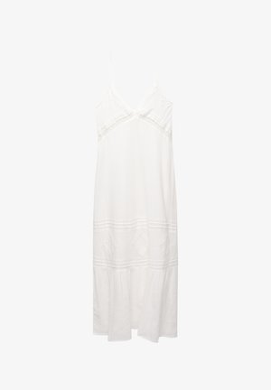 White linen dress with thin straps, V-neck, embroidered accents, tiered hem, and a loose fit. Features textured fabric and lace details.