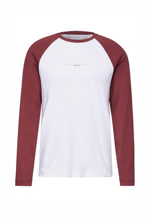 Langærmet skjorte med hvid krop og burgunder raglanærmer. Har et enkelt trykt design i midten. Blødt bomuldsstof.