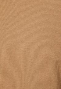 Rippeliger beige Stofftextur, sanftes Erscheinungsbild, mit einem konsistenten Muster ohne auffällige Hardware oder Akzente.