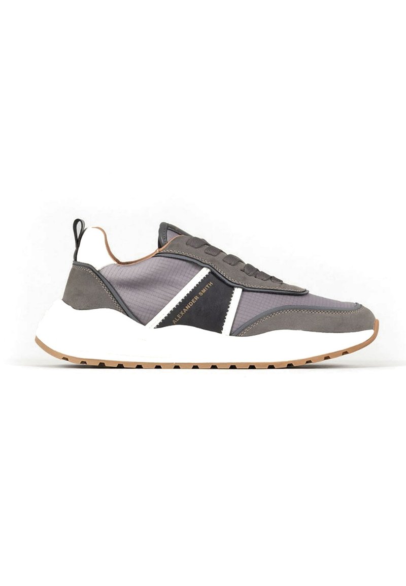 Scarpe sportive grigie e bianche che presentano un mix di materiali testurizzati, una suola spessa e un dettaglio nero a contrasto sul lato.