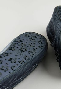 Tengeri slip-on cipők, texturált gumitalppal, csillag és hold mintákkal. Puha szövet felsőrész diszkrét fényű, zárt orrú kialakítással.
