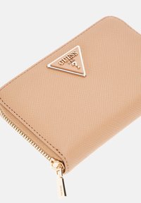 Portafoglio beige con superficie testurizzata, hardware dorato, logo triangolare e chiusura con zip. Design compatto e rettangolare.