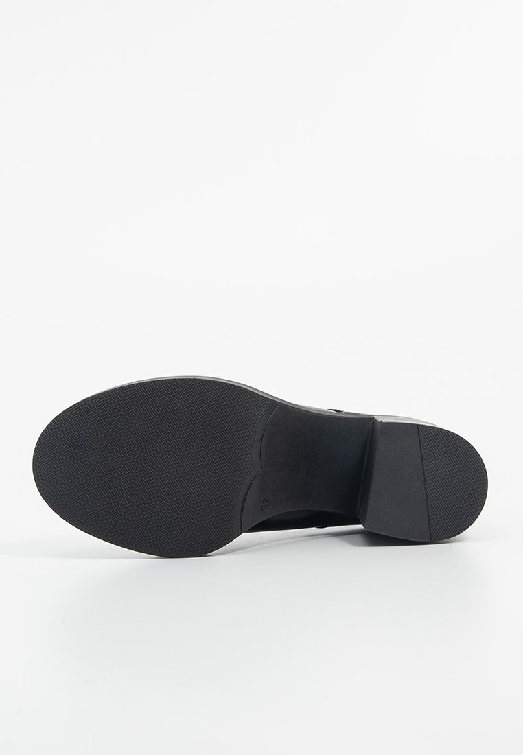 Semelle de chaussure noire avec une finition lisse, présentant un fond en caoutchouc texturé et un talon légèrement surélevé. Détail de taille estampé visible.
