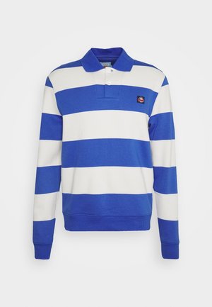 Blå og hvid stribet langærmet polo skjorte med krave, med et lille logo patch på brystet og ribbede cuffs.