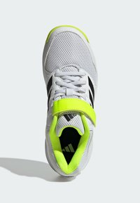 Scarpa sportiva bianca con tomaia in rete; presenta accenti neri, una fascia gialla brillante e una suola testurizzata.