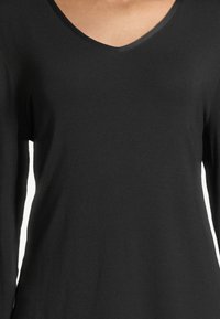 Schwarzes Langarmoberteil mit V-Ausschnitt, aus weichem Stoff gefertigt, mit glatter Textur und schmaler Silhouette.