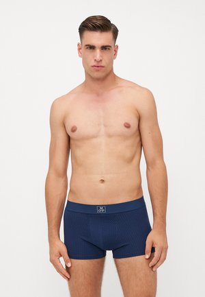 Dunkelblaue Boxershorts mit strukturiertem Muster und einem einfarbigen Bund. Der Stoff wirkt weich und bietet einen engen Sitz.