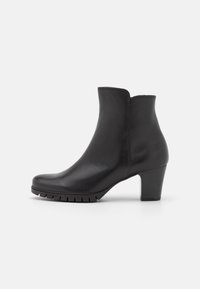 Černá kožená kotníková bota s kulatou špičkou, texturovanou podrážkou a středním blokovým podpatkem. Vyznačuje se hladkým povrchem a minimalistickým designem.
