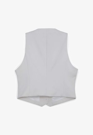 Veste blanche à texture lisse sans manches, présentant un design arrière simple et un ourlet incurvé. Coutures minimales visibles.