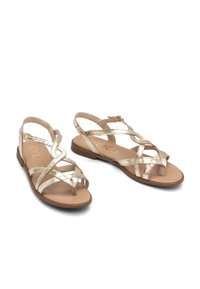 Gouden metallic sandalen met straps, een vlakke zool en een verstelbare enkelband. Glad nepleer materiaal met een minimalistisch ontwerp.