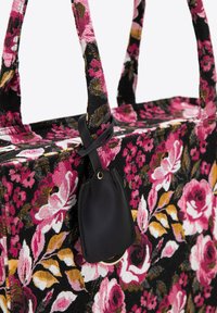 Borsa tote con un motivo floreale nero caratterizzato da accenti rosa e dorati, realizzata in tessuto, con due manici robusti e un piccolo dettaglio tag nero.
