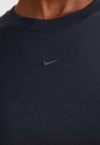 Tengerészkék crew neck póló sima pamutkeverékből, finoman hímzett fekete Nike logóval a mellrészen.