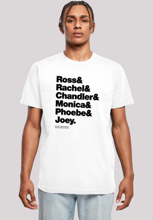 White t-shirt featuring large black text listing character names from a TV show, with the word "FRIENDS" beneath in smaller font.