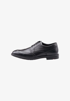 Chaussure Oxford homme en cuir noir à bout golf, ornée de détails brogue et semelle en caoutchouc noir, vue de profil sur fond blanc.