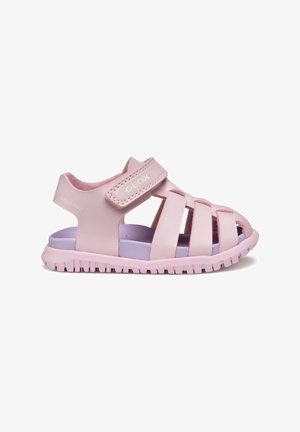 Sandalias rosas con un diseño de tiras, hechas de material sintético suave. Cuentan con una correa de velcro y una suela acolchada de color púrpura claro.