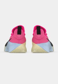 Αθλητικά παπούτσια Nike με ροζ επάνω μέρος από σουέντ, μαύρο λογότυπο και μπλε λαστιχένια σόλα. Διαθέτουν υφή στη φτέρνα και περιμετρικό κολάρο αστραγάλου για υποστήριξη και κράτημα.