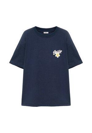T-shirt bleu marine à manches courtes avec col rond et petit texte blanc ainsi qu’un motif fleur jaune sur la poitrine gauche.
