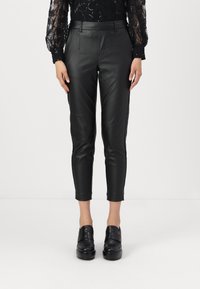 Pantalones de cuero sintético negros con un corte ajustado, que presentan una cintura alta y un largo recortado. Textura suave y diseño minimalista.