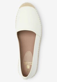 Valkoinen kanva espadrille, jossa on juuttikorkoinen kärki. Sisäpuolella vaaleanruskea teksturoitu vuori. Kultainen logo leimattu sisäpohjaan.