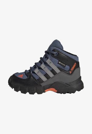 Chaussure de randonnée mi-haute avec une tige en maille bleu foncé, un capuchon en caoutchouc noir, des rayures grises et des accents orange sur la semelle ; semelle extérieure texturée pour l'adhérence.