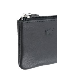 Portafoglio in pelle nera con una texture liscia, dotato di chiusura a zip e un logo in rilievo discreto. Forma compatta e rettangolare.