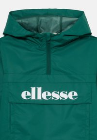 Zeleno kapuco z zadrgo spredaj in velikim žepom na prsih s flapom, ki prikazuje belo besedilo "ellesse".