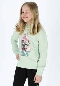 Felpa verde menta con una grafica di un cane sopra un cupcake, con dettagli di glassa rosa. Polsini e orlo aderenti, materiale morbido.