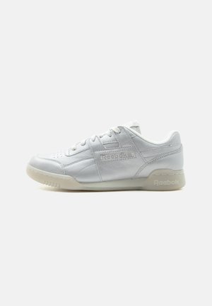 Pantof sport alb cu talpa joasă Reebok, cu partea superioară din piele, cu închidere cu șiret și talpă bej, arătat din partea interioară pe un fundal simplu.