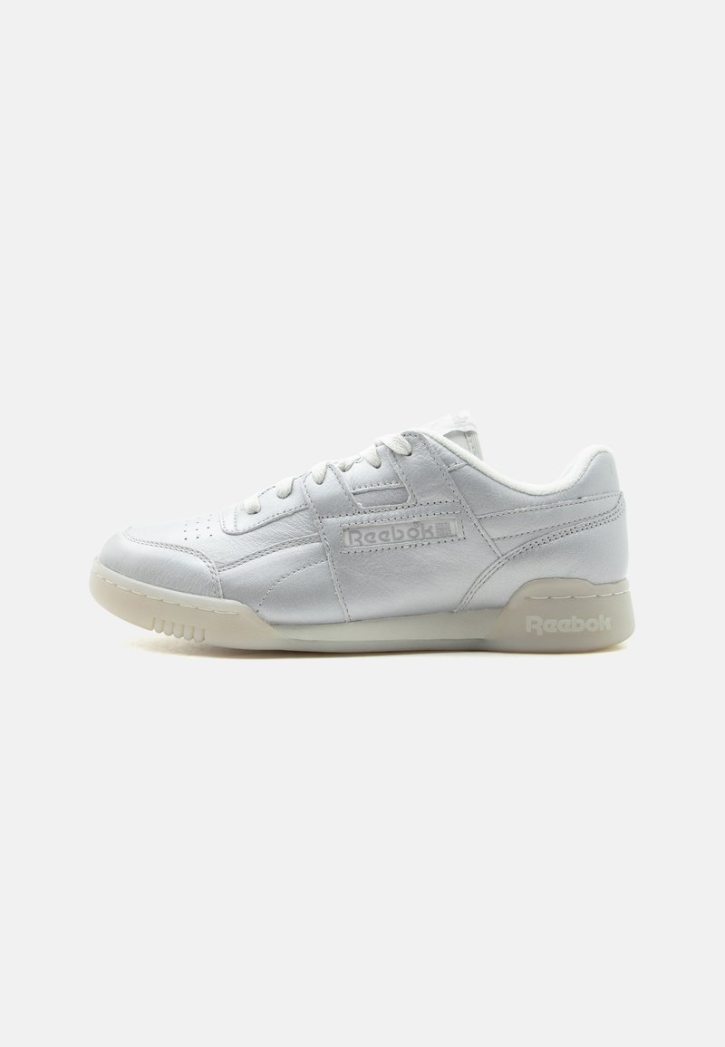 Άσπρο χαμηλό sneaker της Reebok με δερμάτινο επάνω μέρος, κλείσιμο με κορδόνια και μπεζ σόλα, εμφανισμένο από την εσωτερική πλευρά σε απλό φόντο.