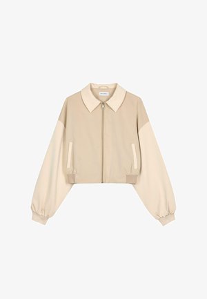 Beige cropped jas met een kraag, ritssluiting en lange, geplooide mouwen. Heeft contrasterende lichte mouwen en zijzakken. Gladde textuur.