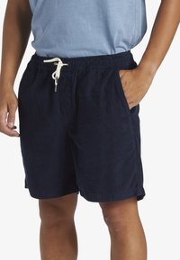 Navy corduroy shorts with a drawstring waistband, side pockets, and textured fabric. Features a relaxed fit and above-the-knee length.