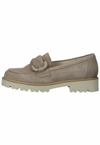 Mocassino in suede beige con un accentuato fiocco decorativo, superficie testurizzata e una spessa suola in gomma bianca con scanalature antiscivolo.