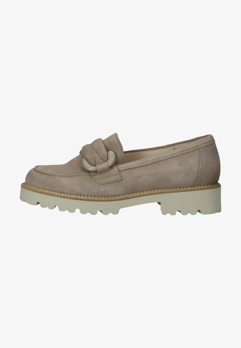 El mocasín de ante beige presenta un destacado lazo, una superficie texturizada y una gruesa suela de goma blanca con surcos de tracción.