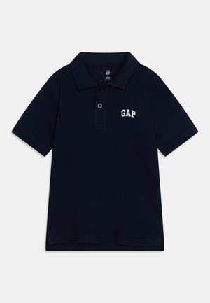Polo bleu marine à manches courtes avec deux boutons et logo « GAP » brodé sur le côté gauche de la poitrine.