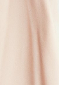 Lyst ferskenfarvet stof med en glat tekstur, der har subtile lodrette linjer og en let glans, velegnet til beklædning eller bløde møbler.