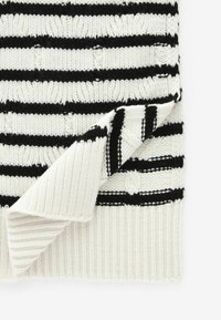 Tissu tricoté à rayures en noir et blanc avec une texture côtelée ; présente un bord replié qui révèle des rayures alternées et un motif texturé.