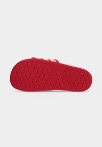Κόκκινο πέλμα σανδαλιού Adidas slide με μοτίβο πέλματος σε σχήμα διαμαντιού και ανάγλυφο λογότυπο Adidas κοντά στη μέση.