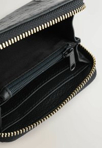 Black zippered wallet with textured exterior, gold metal zipper detailing, multiple card slots, and a zipped compartment.