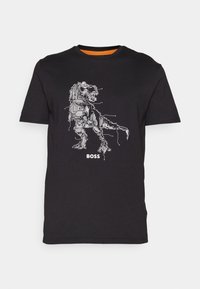 Svart T-shirt med en vit dinosaurgrafik i kretskortsstil och ordet "BOSS" nedanför, rund hals och korta ärmar.