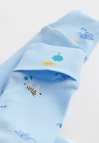 helehele sinised beebisukad loomade trükiga, sealhulgas sebra, elevandi, puu ja päikesega valgel taustal.