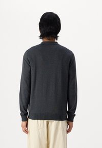 Mörkgrå långärmad tröja med ribbad nederkant och ärmslut, tillverkad av ett mjukt stickat material; har en klassisk krage och en figurnära design.