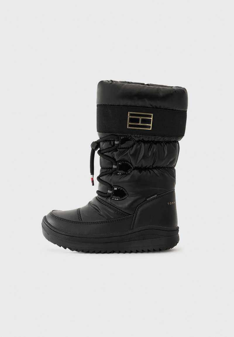 Botas de invierno impermeables negras con una parte superior acolchada, cordones ajustables y suelas texturizadas. Acento del logo dorado en el talón.
