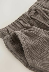 Gray ribbed fabric shorts featuring an elastic waistband and textured surface, with a folded edge and drawstring detail.