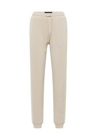 Beige sweatpants tillverkade av mjukt tyg, med dragsko i midjan och elastiska muddar. Märkbar logotyp tryckt i ljusgrått på ena sidan.