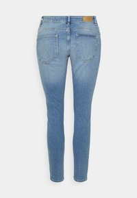 Jeans blue slim fit feitos de denim. Apresentam uma cintura média, design clássico de cinco bolsos e um emblema de pele na parte de trás da cintura.