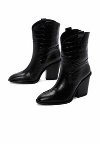 Stivaletti neri in pelle con texture a forma di coccodrillo, punta affusolata e tacchi a blocco robusti. Dotati di linguette per un facile indossamento.