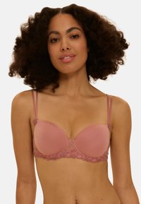 Soutien-gorge rembourré rose avec détails en dentelle et broderie, doté de bretelles doubles réglables et d'un tissu lisse pour un look sans coutures.